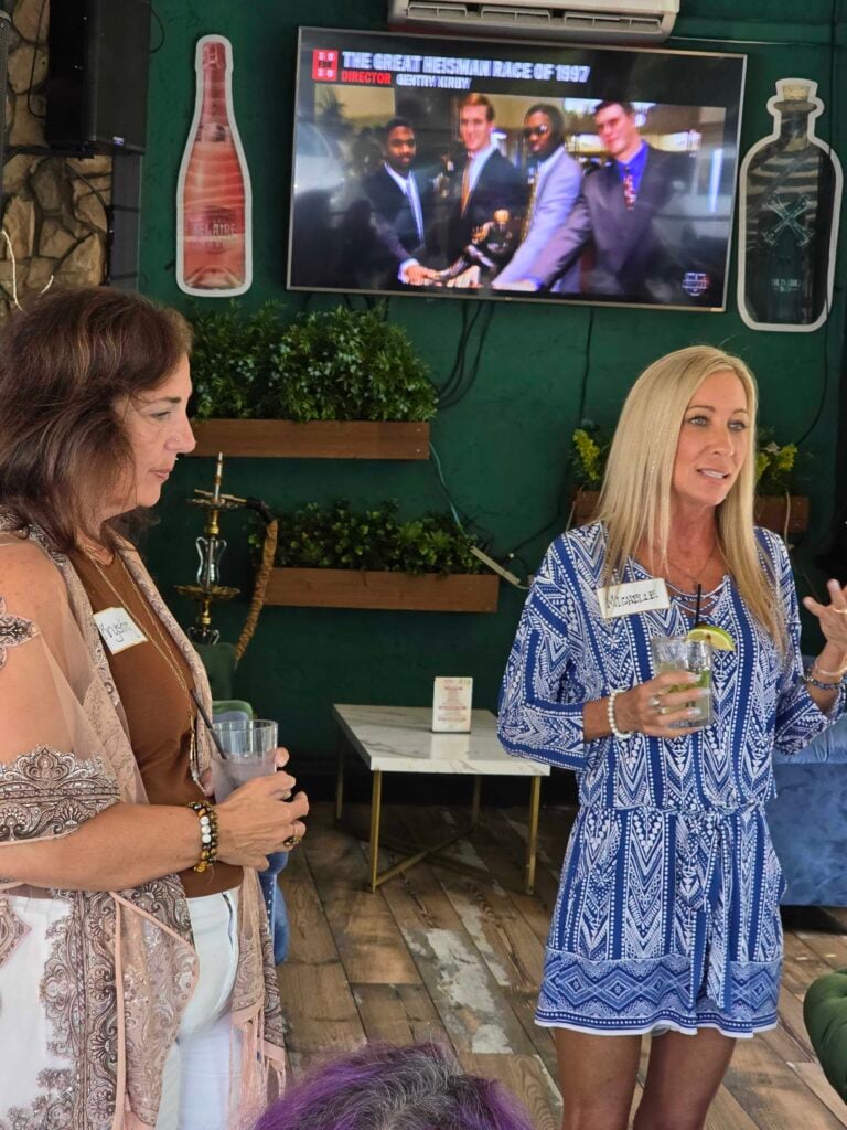 “Woman speaking at a networking event while others listen, representing leadership and connection at Women’s Business Connections”