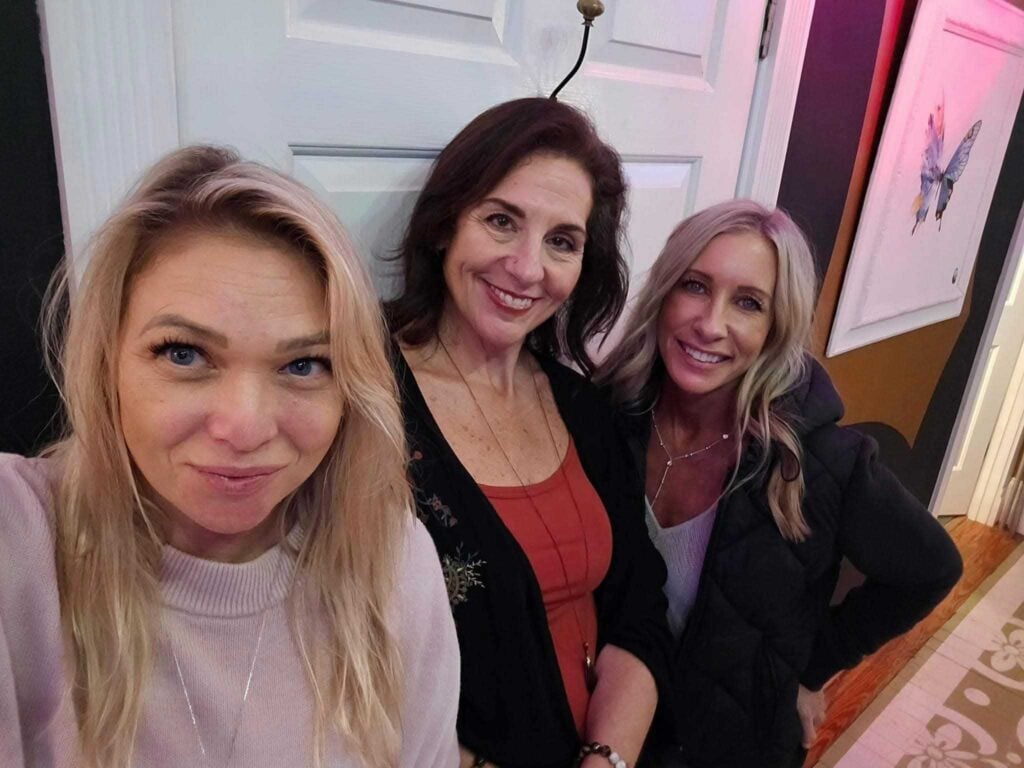 “Three women smiling together, representing friendship, connection, and community at Women’s Business Connections”