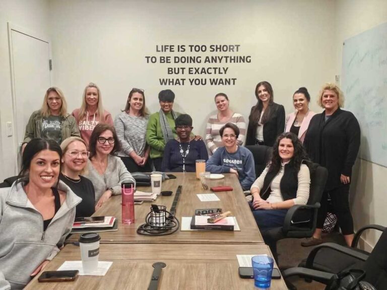 “Group of women gathered in a meeting room, representing collaboration, leadership, and community at Women’s Business Connections”